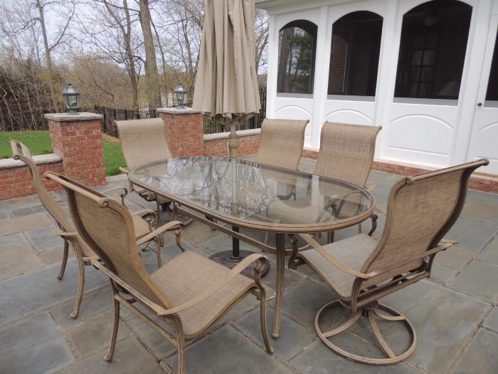 patio table with 4 chairs and two swivel chairs, and umbrella