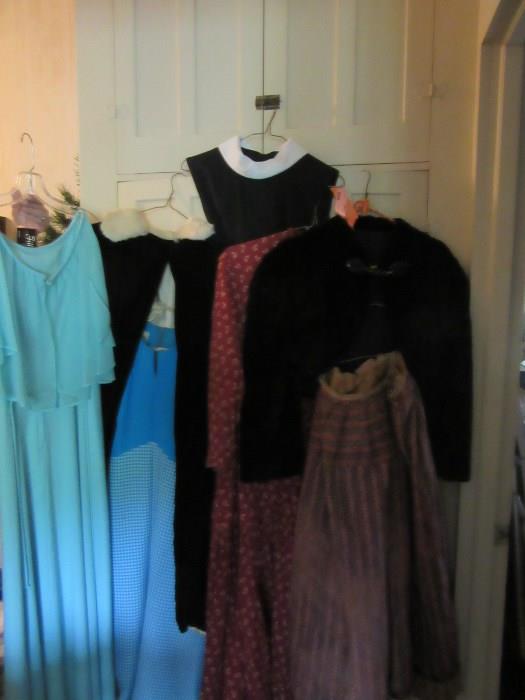 This is a sample of the vintage clothing The blue dress on the left 1950's, next to it the black velvet cape has a white fur collar(1890-1920), the black dress w white collar, the cotton dress, the hand made Victorian jacket(1860-80), and the cotton skirt. There is much more!!!