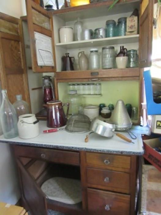 This Sellars cabinet is in very good condition for its age. The lower cupboard stores items the drawers are all good and the enamel top has on small abrasion.  The blue bottles on the top shelf are Atlas or Ball  early canning jars,  The Dietz lantern on the left is marked "Blizzard"