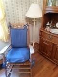 One of many rocking chairs and a floor lamp
