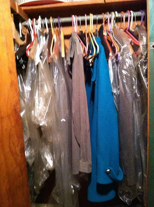 Several closets full of men's and women's clothing.