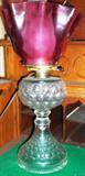 Oil lamp with cranberry shade converted to electricity This is one of several oil lamps converted to electricity.