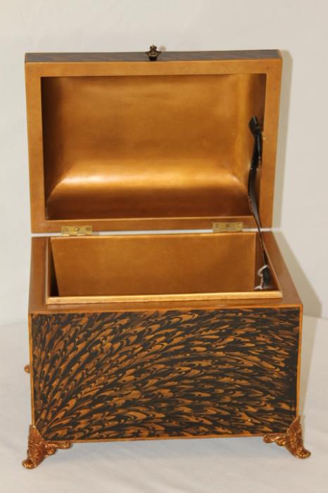 Furnishing – Decorative box. Piece resembles a treasure chest. Golden inside and black and golden pattern exterior. Footed piece. Marked Maitland-Smith. In very nice condition