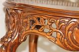 Furnishing – Small side table. Piece is round and wooden with carved trim. Piece has raised metal trim on half the table top. Legs are decorative and curved in. Table top trim is raised on one part. Nice sturdy piece