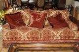 Furniture – Couch. Plush piece with throw pillows. Piece has fringed bottom. Upholstered piece with beige background and red symmetrical pattern. Piece marked Century Hickory Inc. Nice piece in good condition