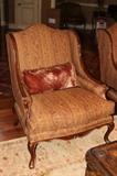 Furniture – Single piece upholstered armchair. Piece has wooden frame and decorative wooden legs. Gilding to wooden trim. Cushioned seats and throw pillow included. The upholstery is maroon and brown patterned. Piece is in very nice condition