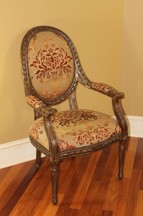 Furniture – Group lot of eight armchairs. Pieces have wooden frame with upholstered seat back and seat cushion. A beige base with red and orange floral pattern. Base and legs are carved. Golden accents throughout. Very nice condition. Piece marked Marge Carson.