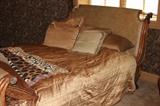 Furniture – Wooden sleigh bed frame. Bed has wooden frame with upholstered head and foot boards. Head board has decorative metal eagle heads on side. Base board has decorative metal feet. Note: Mattress is NOT included
