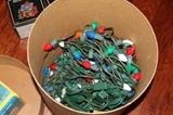 Miscellaneous – Christmas accessories. Round container of Christmas lights, one earthenware snow house cookie jar, and three ceramic candle snow houses. All houses are still in original packaging.