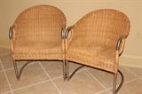 Furnishing – Pair of wicker arm chairs. Pieces have metal frame. In good condition.