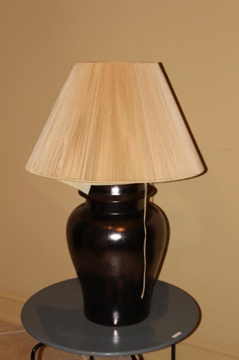 Furnishing – Table top lamp. Base is a deep brown large piece. Beige shade with pleating. Base is crackled.
