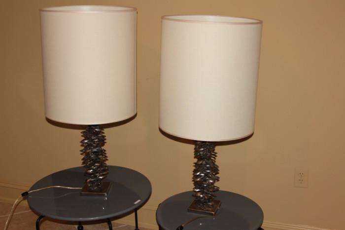 Furnishing – Pair of table top lamps. Pieces have uniquely designed bases created with metal stackable ovals with white cylindrical shades. Great set.