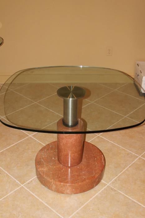 Furniture – Square side table. Glass table top with one pedestaled leg. Piece is metal with a neutral marble base. In good condition.
