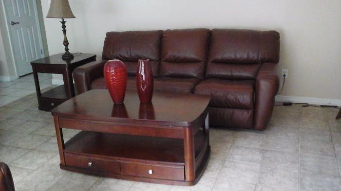 One of two matching leather sofas. Each has left
and right recliners. Shown with coffee table that has two matching lamp tables. 