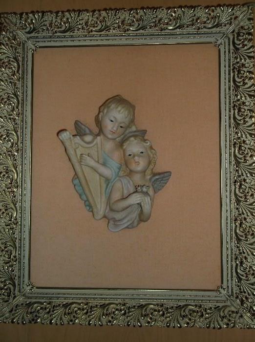 One of a pair of framed cherub porcelain plaques