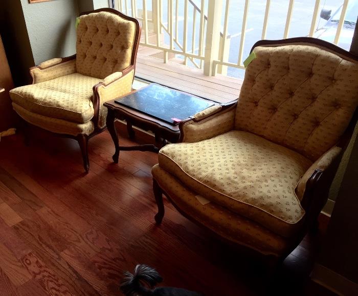Pair of vintage gold silk French Provincial chairs and black marble topped side table.