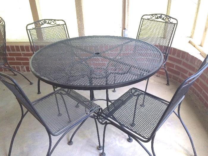 Vintage wrought-iron patio table with slimmer chairs, no arms
