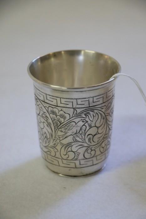 The very fine quality cup engraved with an intricate foliate and bird design, two lions flank Hebrew writing (roughly "bless this event" or similar, in translation).  The cup is appx. 2 7/8" tall.  Marked with unknown hallmarks on base ("12" in square box, another mark more central), possibly (probably) silver.  Probably Poland or Ukraine, maybe 18thC, no later than 1820-1830.  