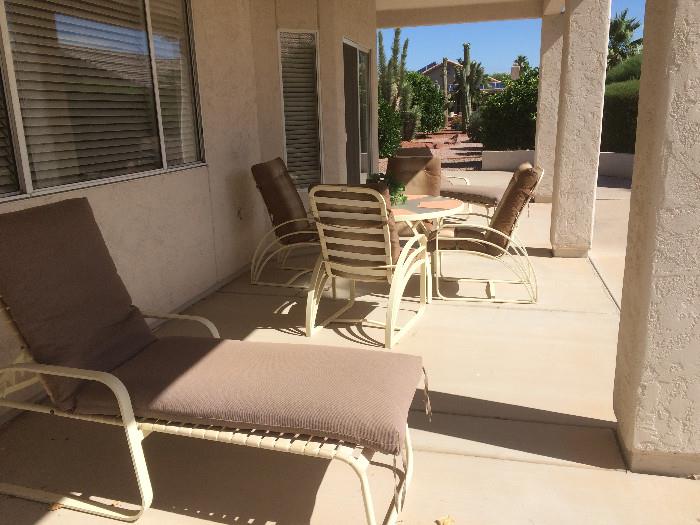 Patio furniture.  Table with four chairs and two lounge chairs.