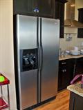 Whirlpool side-by-side refridgerator w/ water and ice dispenser.