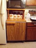 Look close, this is a refridgerator with a custom built oak counter top shelf unit.