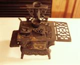 Larger Vintage Crescent Miniature Cast Iron Stove with several accessories.