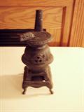 Small cast iron stove with a stove pipe.
