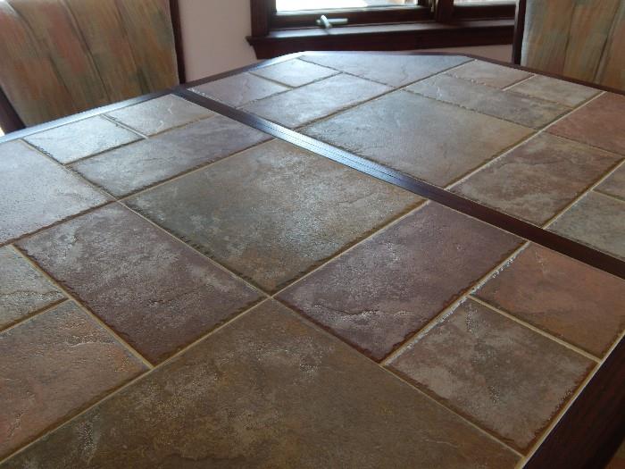 table top in stone tile, with hide away leaf built in the table for storage.