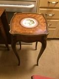 French style occasional table of fruit wood, walnut and mahogany with Sevres style porcelain plate in center.
