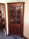 Mahogany corner cabinet with glass front.