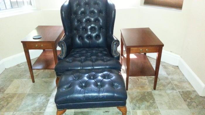 Leather tufted wing chair, nail head details, ottoman, pair of mahogany side tables