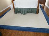 Custom made white wool rug with and 8" blue border. Measures 10' x 13'