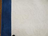 Close up detail of the custom made white wool rug with and 8" blue border. Measures 10' x 13'