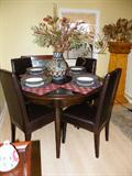 Excellent condition kitchen or dining room table and leather chairs. Includes one leaf to make the table oblong.