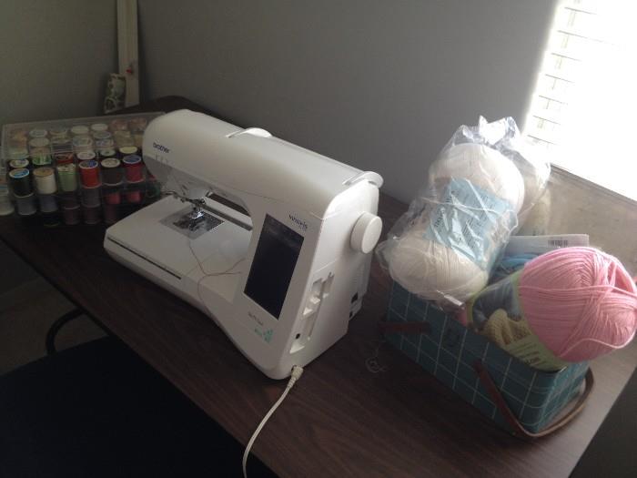 Brother Innovis QC 1000 sewing and embroidery machine in a room full of notions, patterns, yarn and more.