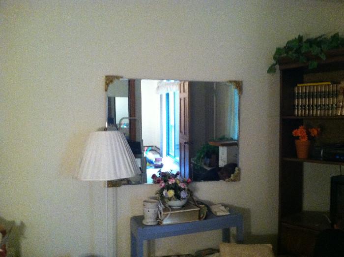 Mirror and another lamp. Bookshelf in corner.