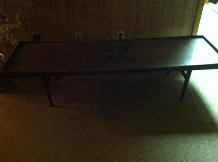 Long coffee table with inlaid detail. Sorry it's in a poorly lit spot in the house.