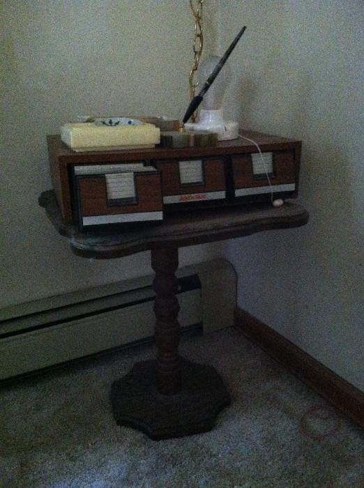 Small table, and a cassette tape collection.
