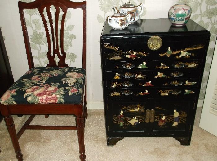 One of two mahogany chairs and black lacquer silverware cabinet