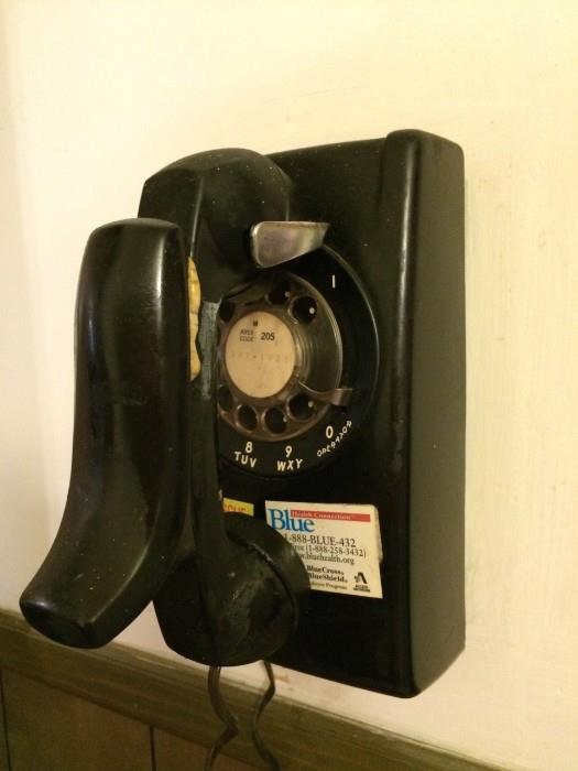 Vintage black rotary wall phone, complete with shoulder rest