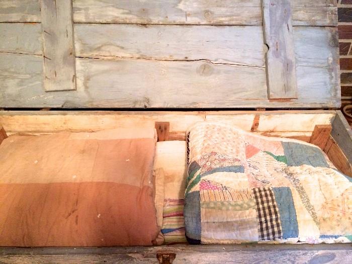 Interior of primitive quilt chest with quilts