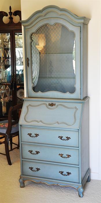 Wonderful secretary in blue with gold trim.  Has a bubble glass door with gold accents.  Display top is lighted.