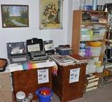 Vintage typewriters on 2 very nice lateral files next to a shelf unit full of Tupperware