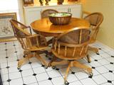 oak breakfast table with 4 windsor style chairs on casters.