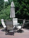 Table, umbrella, and four chairs, two with swivel bases