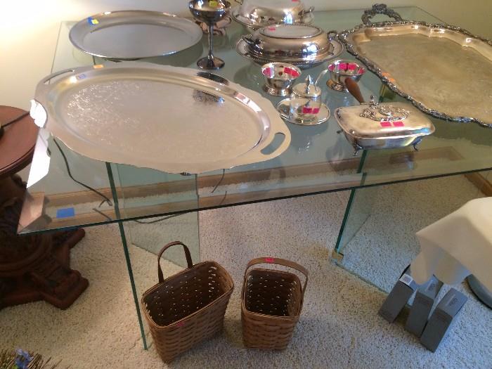 all-glass table with silver serving pieces on it