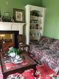 One of 5 sofas; glass top coffee table; cane chair; Staffordshire-style dogs; other decorative items; fabulous rug in greens/reds
