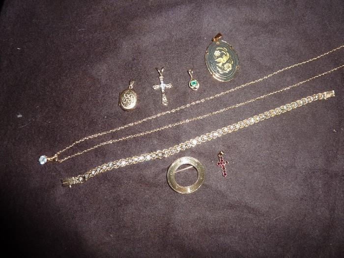Gold and Diamond Necklace, Gold and Diamond Bracelet, Gold Pin (round) sterling and ruby cross pendant, (top row) Gold locket, gold and diamond cross, gold and emerald pendant, gold pendant