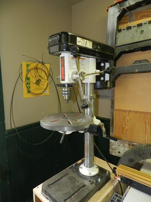 Shop Fox Bench Top Drill Press on cabinet.