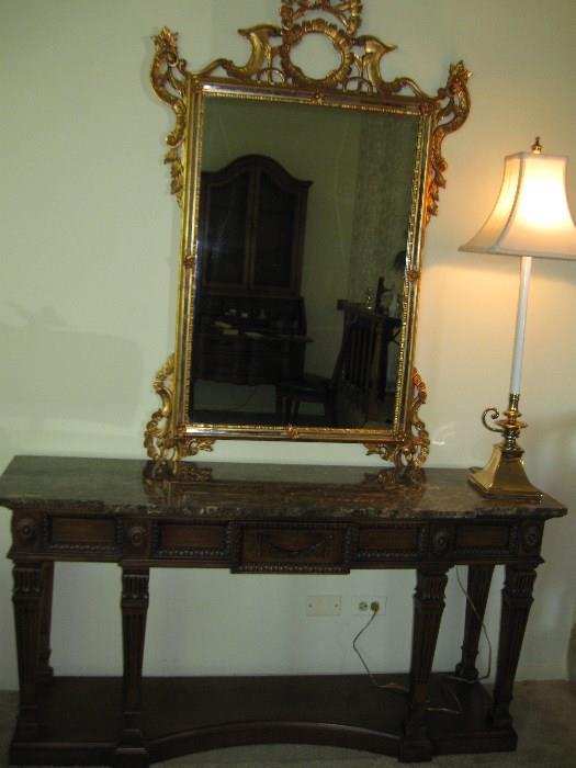 Sideboard with ornate mirror and tall candlestick lamp